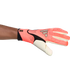 A pink and black Adidas goalkeeper glove with "URG 2.0+" branding, worn on a left arm and shown horizontally against a white background.