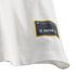 Close-up of a white shirt hem featuring a black and gold woven patch with logos for Adidas, Thrasher magazine, and the Argentine Football Association (AFA).