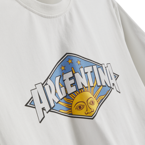 A white t-shirt featuring a diamond-shaped graphic with the word "ARGENTINA" in bold letters over a yellow sun with a face and three gold stars.