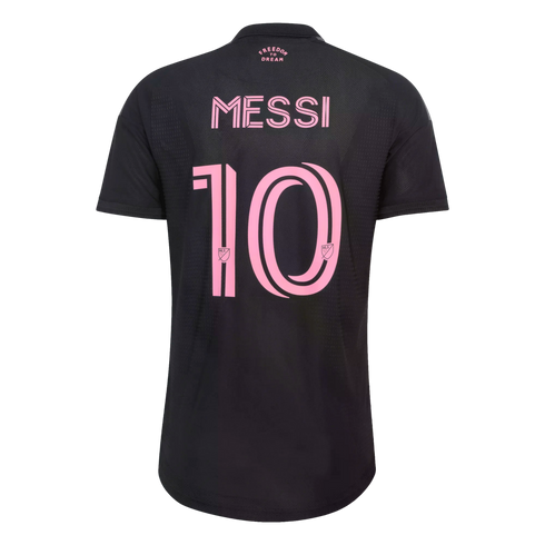 The back of a black soccer jersey with the name "MESSI" and the number "10" printed in a large, stylized pink font. Small pink text at the top reads "FREEDOM TO DREAM."