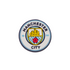 A circular Manchester City Soccer Croc Charm featuring the team's blue and white crest with a gold ship and a red rose.