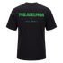 Back of a black t-shirt featuring "PHILADELPHIA" in large green block lettering above several smaller green Nike Soccer logos.