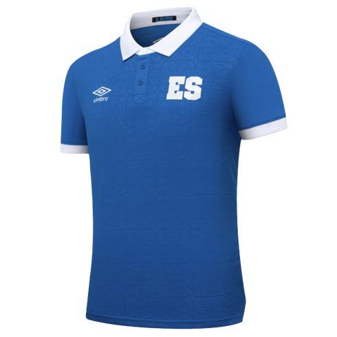 A royal blue El Salvador Umbro polo shirt with white collar and cuffs, featuring a large white "ES" on the chest and a subtle tonal geometric pattern throughout.