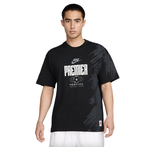 A man wearing a black Nike Premier Football graphic t-shirt and white shorts against a white background.