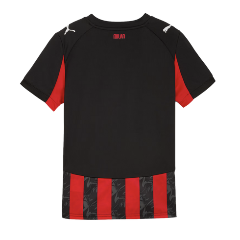 Back view of a black Puma AC Milan soccer jersey with red accents. Features "MILAN" text on the neck and red-and-black striped detailing at the bottom hem.