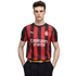 Young man wearing a red and black striped AC Milan soccer jersey, black trousers, and a tan belt, posing against a white background.