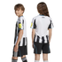 Two youth models wearing a black and white striped soccer kit. The girl displays the back with 'HOWAY THE LADS' text, and the boy faces sideways.
