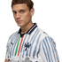 A man in a white Puma football jersey featuring light blue brushstroke stripes, a central green and red stripe, and the Monterrey club crest.