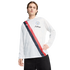 A man in a white Puma x KidSuper Manchester City long-sleeve polo featuring a red and navy sash, paired with black pants.