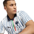 Close-up of a man looking away, wearing a white soccer jersey with blue painted stripes, a Puma logo, and a CF Monterrey crest.