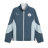 A teal and light blue Puma Manchester City track jacket featuring a white front zipper and the club crest on the chest.