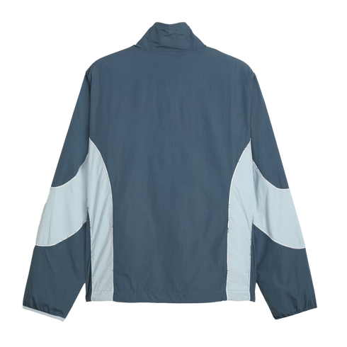 Rear view of a dark blue-grey windbreaker with light blue color-blocked side panels and sleeve details.