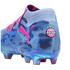 A Puma x KidSuper soccer cleat in light blue with dark blue face graphics, pink accents, and an iridescent sole. A KidSuper Football Club badge is displayed on the heel.
