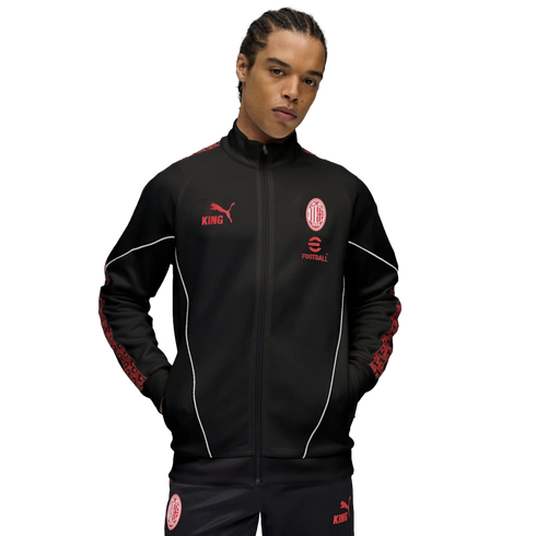 A male model wearing a black AC Milan x Puma 'KING' tracksuit with red accents and white piping, set against a plain white background.