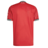 Back of a red football jersey with black and white striped collar and cuffs. "Theatre of Dreams" is printed in white script on the upper back.