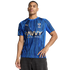 A man modeling an Al Hilal blue striped home soccer jersey with gold Puma and Savvy Games Group logos against a black background.