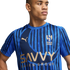A young man wearing a blue Puma Al-Hilal soccer jersey with "SAVVY GAMES GROUP" printed on the chest.