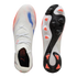 Top and bottom views of a white Puma soccer cleat featuring blue and pink spray-paint patterns and pink studs on a black and white sole.