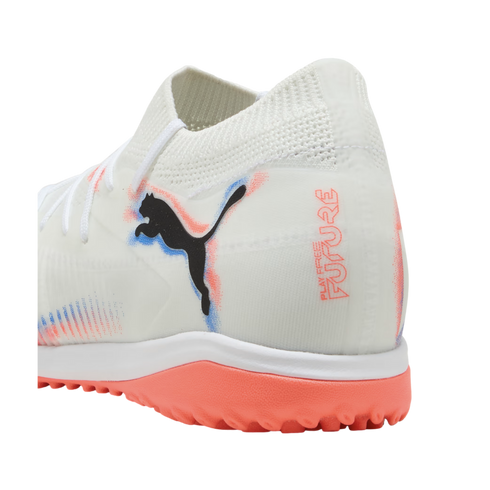 White Puma Future soccer turf shoe with black logo, coral and blue accents, and a bright coral studded rubber outsole.