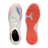 Top and sole view of a white Puma turf soccer shoe with pink and blue accents. It features a white knitted upper, sock-like collar, and a textured orange rubber outsole.