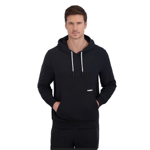 A man wearing a black Umbro hoodie with white drawstrings and hands in the front pocket, set against a solid black background.