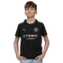 A young boy with light brown hair wears a black Manchester City soccer jersey and light blue jeans, posing with his hands in his pockets against a solid black background.