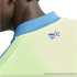 Close-up of a person's neck and shoulder wearing a lime green and blue athletic jersey with a small soccer cleat and ball logo on the back.