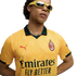 A man wearing a yellow AC Milan soccer jersey with a dark green collar and yellow-framed sunglasses against a solid black background.