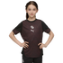 A young girl stands with hands on her hips wearing a maroon and black Puma athletic shirt against a solid black background.