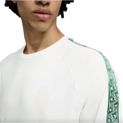 Person wearing a white AC Milan sweatshirt with green patterned sleeve trim and a faint chest crest.
