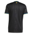 Back view of a black Manchester United football jersey with subtle vertical stripes, embossed tonal devil patterns, and yellow and blue trim on the collar and sleeve cuffs.