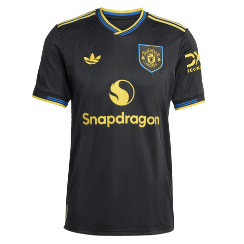 A black Manchester United soccer jersey with yellow Adidas and Snapdragon logos, a club crest, and blue and yellow trim on the collar and sleeves.