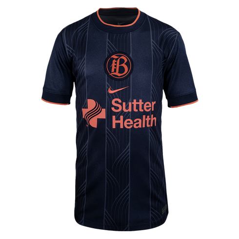 Bay FC navy blue Nike jersey with peach accents, circular 'B' crest, and Sutter Health sponsor logo. Tonal vertical patterns decorate the front.