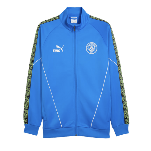 Blue Manchester City track jacket with a full zip, white piping, and club crest. Features a Puma logo and decorative patterned tape running down the sleeves.