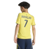 Back view of a boy in a yellow "RONALDO 7" soccer jersey and navy shorts against a black background.