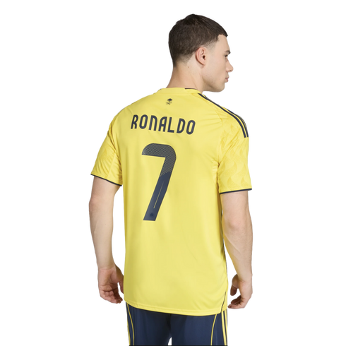 Back view of a man wearing a yellow soccer jersey with "RONALDO" and the number "7" printed in navy blue on the back, set against a solid black background.