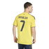 Back view of a man wearing a yellow soccer jersey with "RONALDO" and the number "7" printed in navy blue on the back, set against a solid black background.