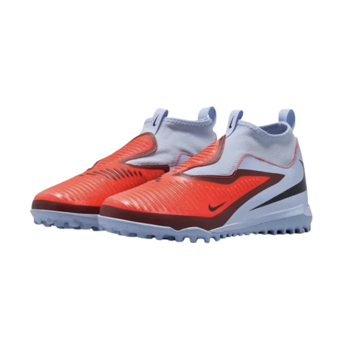 Pair of Nike laceless turf soccer shoes featuring a bright orange forefoot, light blue sock-like collar, and a studded outsole, set against a black background.