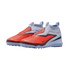 Pair of Nike laceless turf soccer shoes featuring a bright orange forefoot, light blue sock-like collar, and a studded outsole, set against a black background.