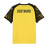 Back of a yellow football jersey with "DORTMUND" in bold black text across the shoulders and patterned black sleeves.
