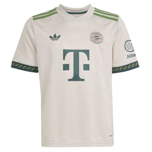 Off-white FC Bayern Munich soccer jersey with green accents, featuring an Adidas trefoil, club crest, and large "T" sponsor logo. Tonal patterns cover the fabric.