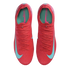 Top-down view of a pair of bright red Nike Mercurial soccer cleats with light blue swooshes and teal insoles, set against a black background.