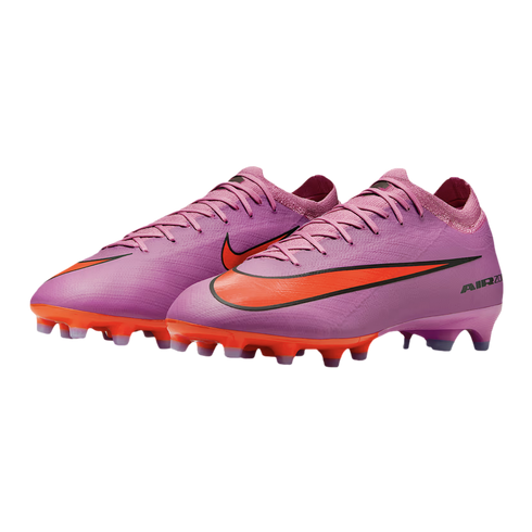 A pair of pink Nike Air Zoom soccer cleats with bright orange accents on the sole and logo, isolated on a black background.