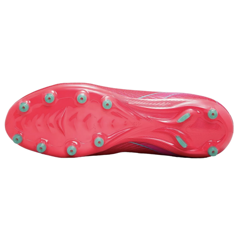 Bottom view of a pink soccer cleat showing the soleplate with light green studs and intricate molded patterns against a solid black background.