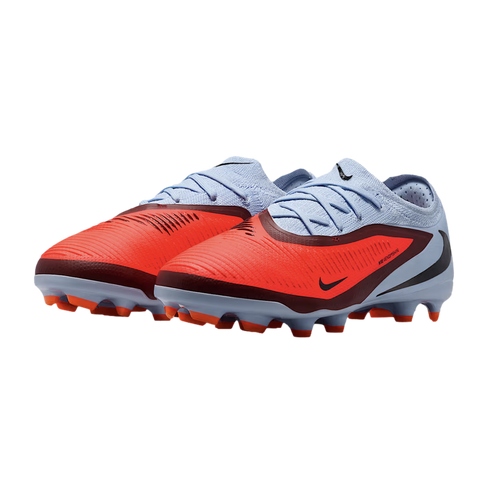 A pair of Nike Phantom Venom soccer cleats with a vibrant orange forefoot, light blue heel, and burgundy accents against a black background.