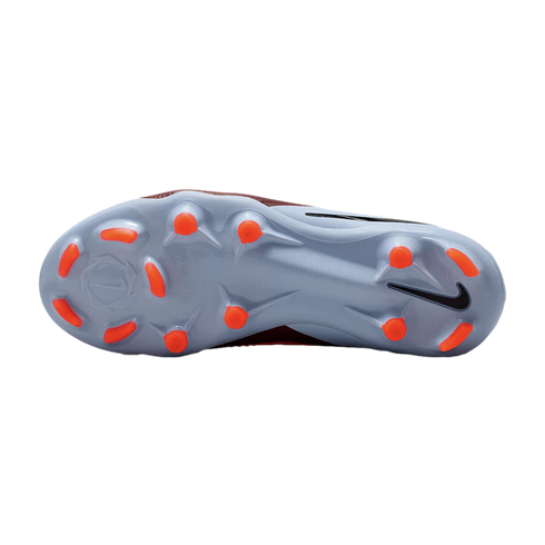 Bottom view of a light blue Nike soccer cleat with orange studs against a black background.