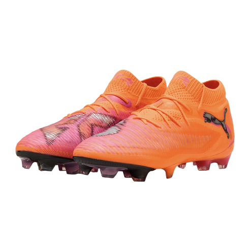 A pair of bright orange and pink Puma soccer cleats with black logos, displayed against a black background.