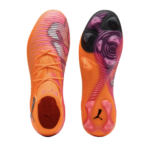 Top and soleplate views of vibrant orange and pink Puma soccer boots with a textured upper and translucent studs, isolated on a black background.