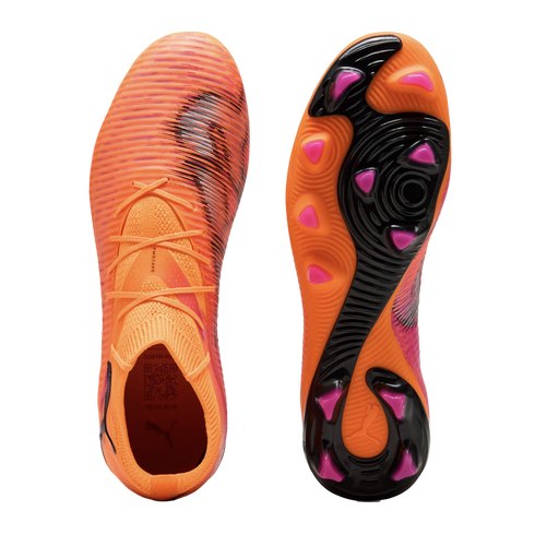 Top and bottom views of orange Puma soccer cleats featuring a textured upper and a pink-studded soleplate against a black background.