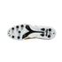 Bottom view of a white Diadora soccer cleat with black studs and gold accents against a black background.